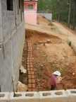 man making mud bricks out our window